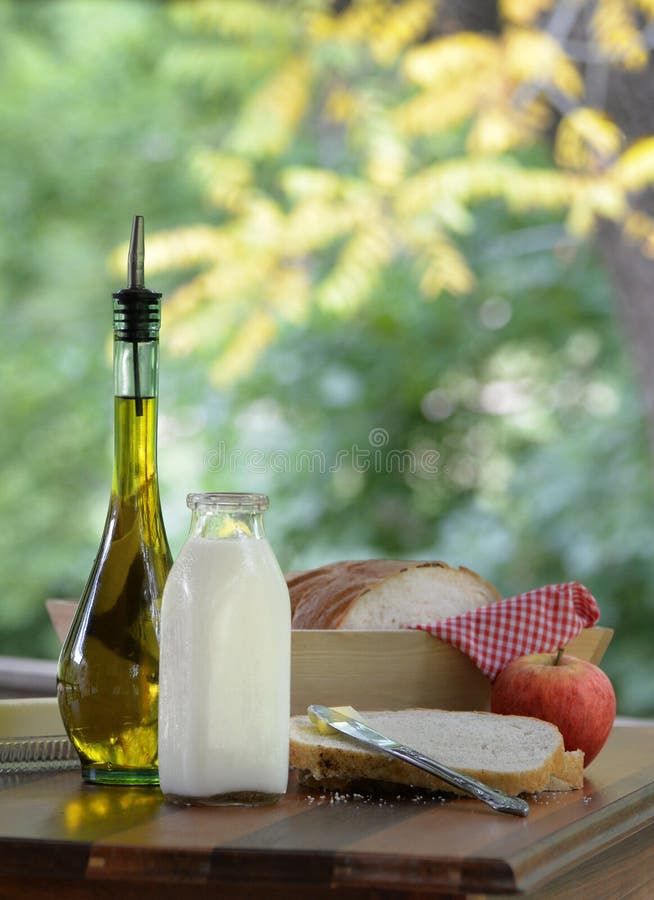 Pan hecho en casa y manzana del aceite de oliva del jarro de leche picinic con estilo al aire libre del vintage imagen de archivo Pan hecho en casa y manzana del aceite de oliva del jarro de leche picinic con estilo al aire libre del vintage imagen de archivo