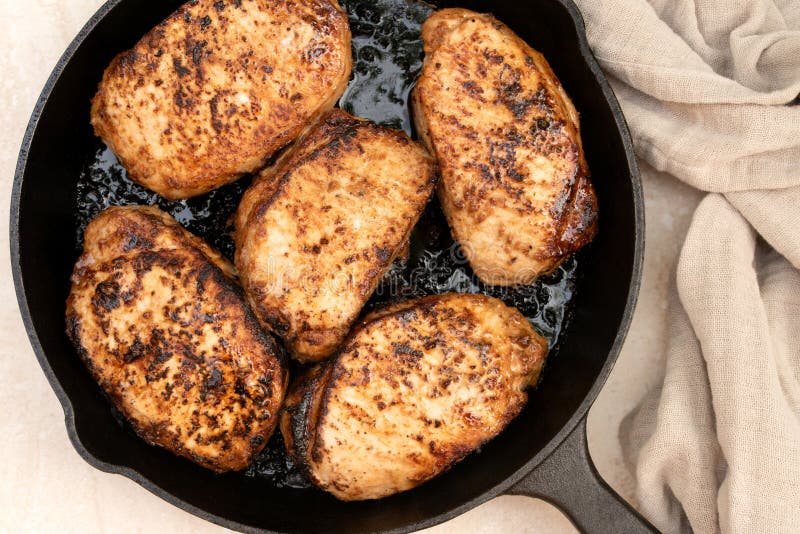 Pan Seared Oven Roasted Thick Pork Chops in a Cast Iron Pan Stock Image