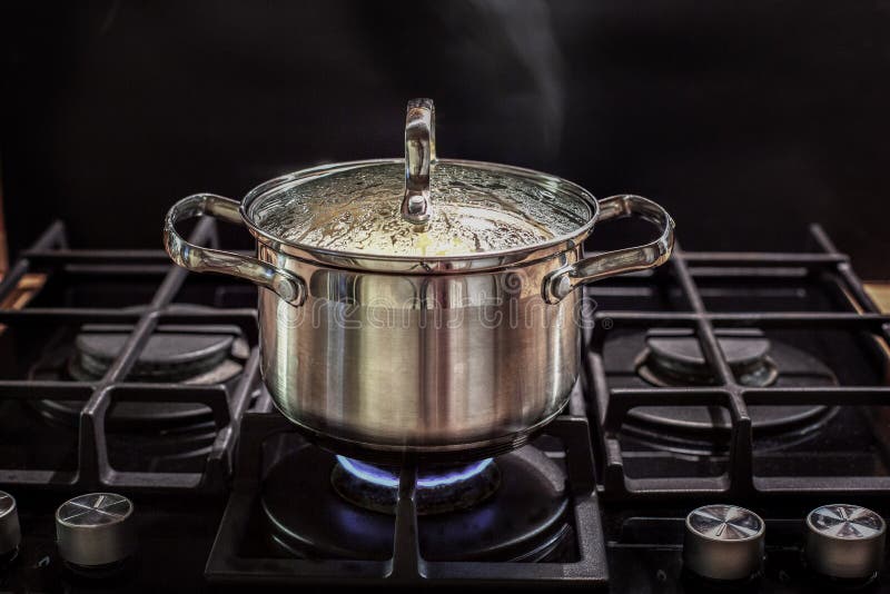 Boiling water in pan. White cooking pot on stove with water and