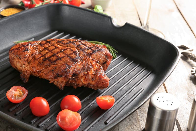 Pan with Tasty Grilled Steak with Rosemary and Tomatoes on Table Stock