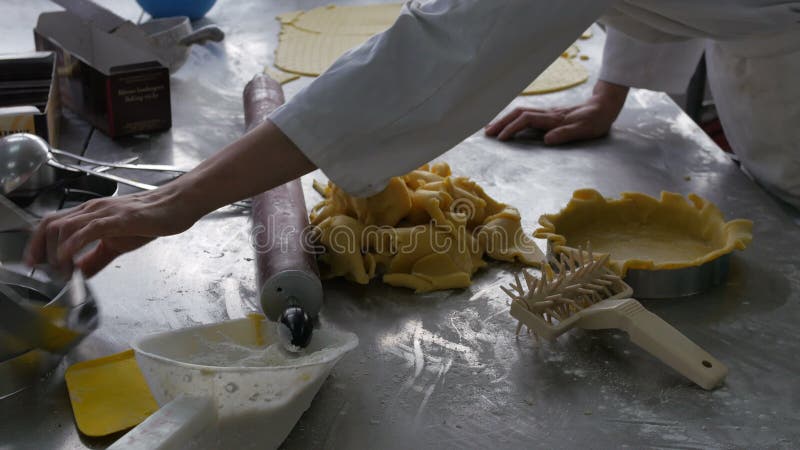 Panadero que llena y que forma cajas de la pasta de pasteles en kitchn industrial