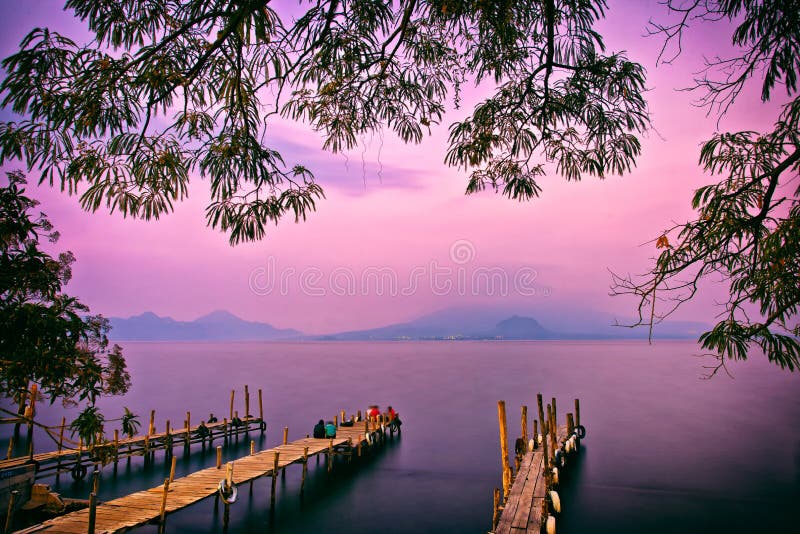 Panajachel Pier at sunset framed with trees in the foreground and copy space, Lake Atitlan, Guatemala, Central America. Panajachel Pier at sunset framed with trees in the foreground and copy space, Lake Atitlan, Guatemala, Central America