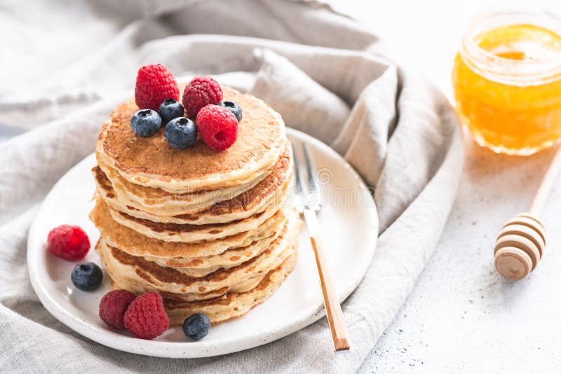 Pancake con le bacche ed il miele fotografia stock libera da diritti Pancake con le bacche ed il miele fotografia stock libera da diritti