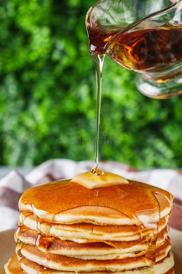 Pancake di sapore fresco con sciroppo d'acero su fondo di pietra leggera.