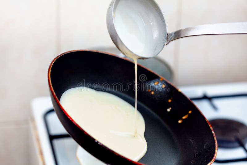 Pancakes in the pan .  Hot pan pours pancake dough with ladle. Pancakes in the pan .  Hot pan pours pancake dough with ladle