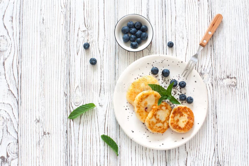 Pancake o syrniki della ricotta con il mirtillo fresco immagine stock