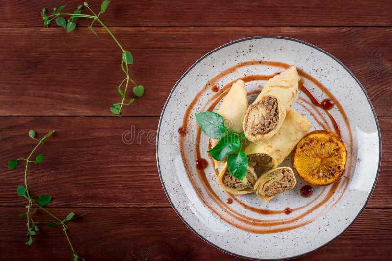 Pancakes stuffed with liver. Wooden rustic background. Top view royalty free stock image Pancakes stuffed with liver. Wooden rustic background. Top view royalty free stock image