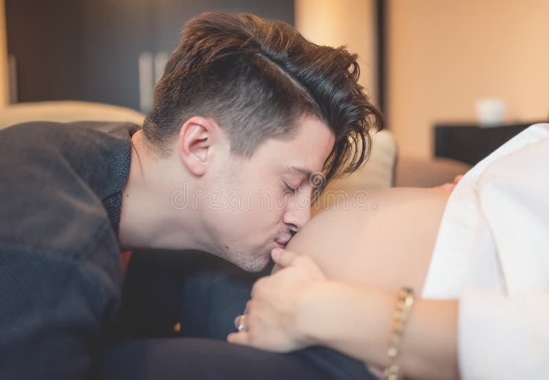 Pancia incinta baciante del giovane padre della moglie Famiglia felice che attende un bambino immagini stock libere da diritti Pancia incinta baciante del giovane padre della moglie Famiglia felice che attende un bambino immagini stock libere da diritti