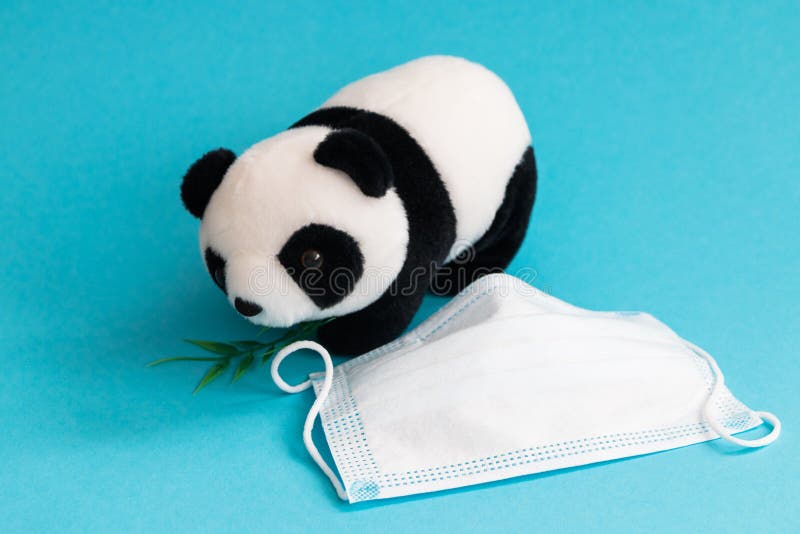 Panda toy and medical mask on blue background. Panda toy and medical mask on blue background