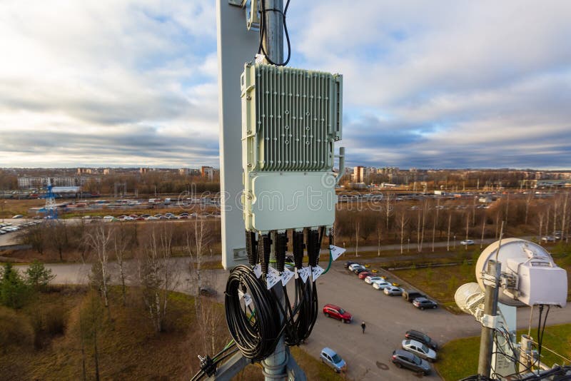 Panel antenna of GSM DCS UMTS LTE bands, GPS antenna and remote radio unit are as part of communication equipment of basic station are installed on the tubular mast and sky and city are as background. Panel antenna of GSM DCS UMTS LTE bands, GPS antenna and remote radio unit are as part of communication equipment of basic station are installed on the tubular mast and sky and city are as background