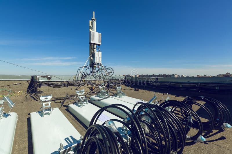 Panel antennas of GSM  DCS UMTS LTE bands and outdoor radio units are as parts of communication equipment of basic station are prepared to  installed on the roof and sky and city  are as background. Working process of upgrading telecommunication equipment. Panel antennas of GSM  DCS UMTS LTE bands and outdoor radio units are as parts of communication equipment of basic station are prepared to  installed on the roof and sky and city  are as background. Working process of upgrading telecommunication equipment