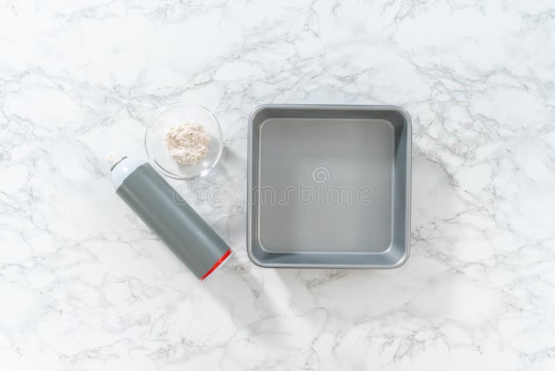 Flat lay. Measured ingredients in a glass mixing bowl to greased baking pan for baking. Flat lay. Measured ingredients in a glass mixing bowl to greased baking pan for baking.