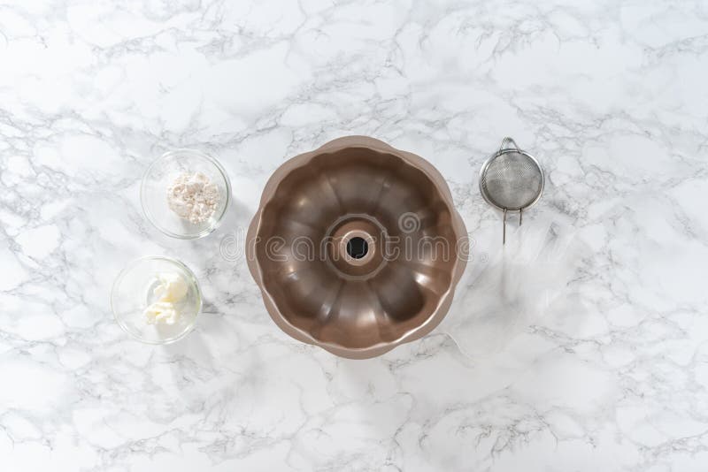 Flat lay. Measured ingredients in a glass mixing bowl to greased baking pan for baking. Flat lay. Measured ingredients in a glass mixing bowl to greased baking pan for baking.