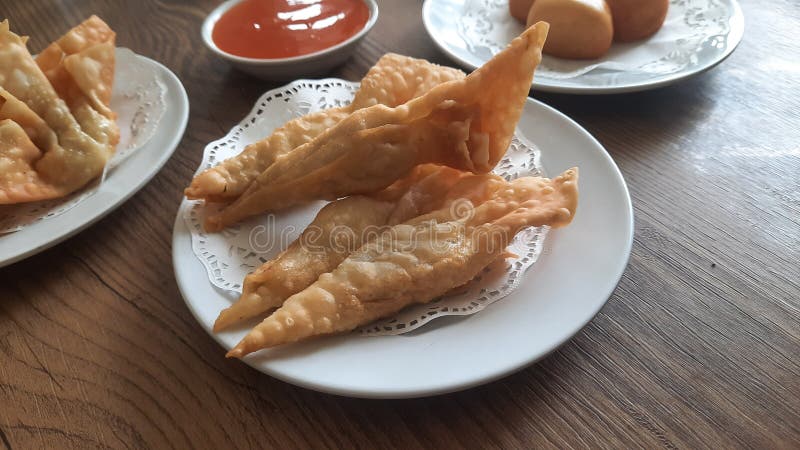 Pangsit, Pangsit Goreng, delicious Pangsit Ayam Goreng (Chicken Fried Dumpling), Indonesia Traditional Food made from flour and chicken, served on white sauce