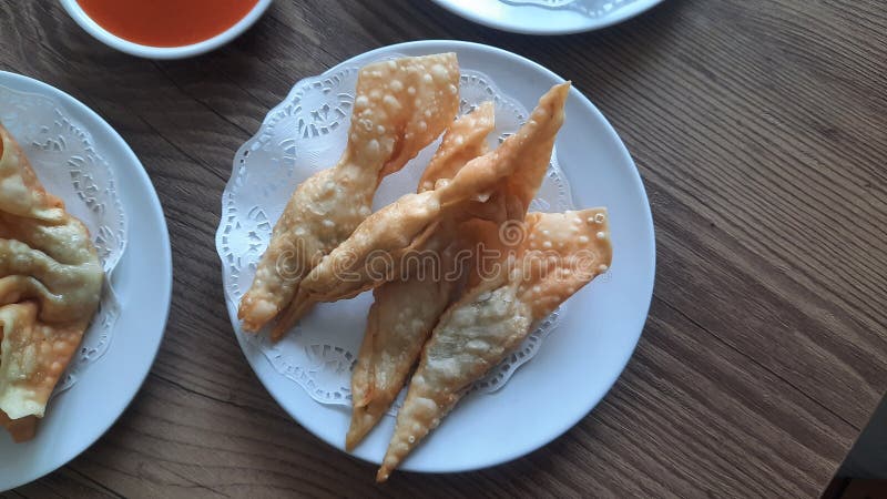 Pangsit, Pangsit Goreng, delicious Pangsit Ayam Goreng (Chicken Fried Dumpling), Indonesia Traditional Food made from flour and chicken, served on white sauce