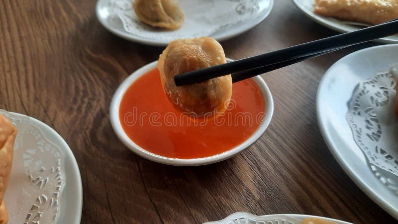 Pangsit, Pangsit Goreng, delicious Pangsit Ayam Goreng (Chicken Fried Dumpling), Indonesia Traditional Food made from flour and chicken, served on white sauce