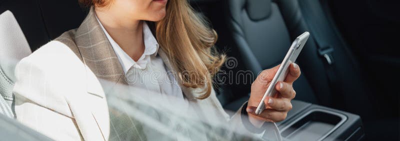 Pani biznesowa korzystająca ze smartfona podczas podróży samochodem Obraz szeroki obrazy royalty free