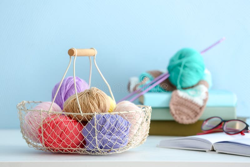 Panier avec les fils à tricoter colorés sur la table à l'intérieur photos libres de droits Panier avec les fils à tricoter colorés sur la table à l'intérieur photos libres de droits