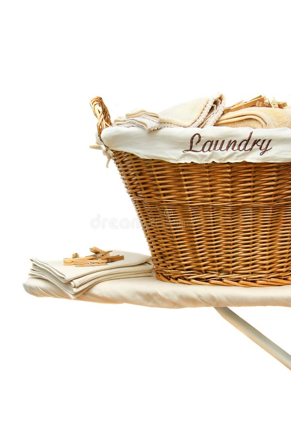 Panier de blanchisserie sur le panneau repassant contre le blanc image stock Panier de blanchisserie sur le panneau repassant contre le blanc image stock