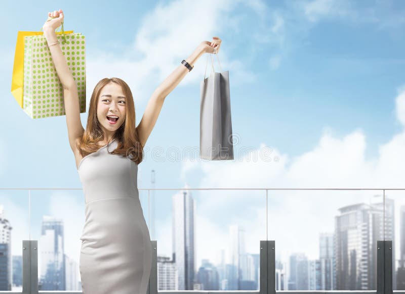 Panieres que llevan de la mujer china feliz en la ciudad imagen de archivo libre de regalías Panieres que llevan de la mujer china feliz en la ciudad imagen de archivo libre de regalías
