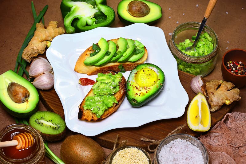 Panini, Bruschetta con l'avocado affettato, avocado verdi delle verdure, pepe, limone, zenzero, aglio, olio, sale marino, insalat fotografia stock Panini, Bruschetta con l'avocado affettato, avocado verdi delle verdure, pepe, limone, zenzero, aglio, olio, sale marino, insalat fotografia stock
