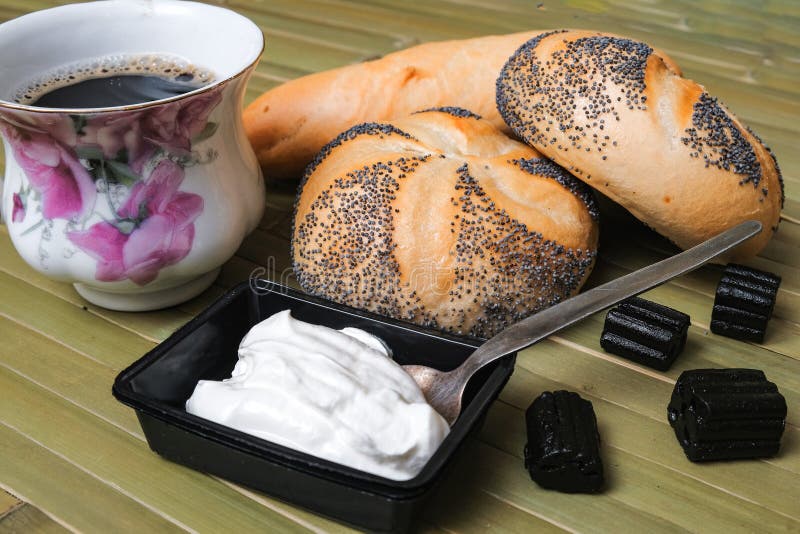 Panini con i semi di papavero e una tazza di caffè fotografia stock libera da diritti Panini con i semi di papavero e una tazza di caffè fotografia stock libera da diritti