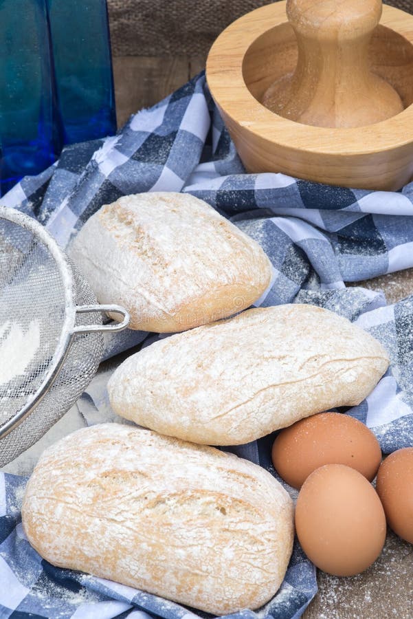 Panini Rolls in Rustic Kitchen Setting with Cooking Utensils Stock