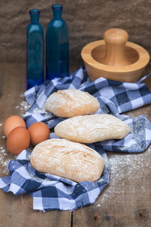 Panini Rolls in Rustic Kitchen Setting with Cooking Utensils Stock