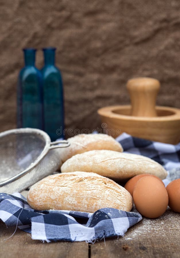 Panini Rolls in Rustic Kitchen Setting with Cooking Utensils Stock