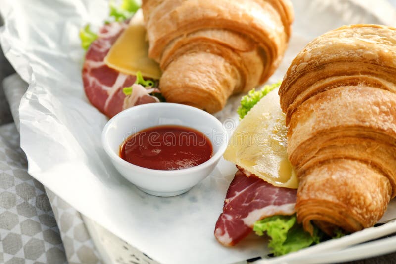 Panini saporiti del croissant con salsa sul vassoio, primo piano immagine stock Panini saporiti del croissant con salsa sul vassoio, primo piano immagine stock