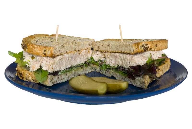 Tuna salad sandwich, on flax toast with pickles on white. Tuna salad sandwich, on flax toast with pickles on white