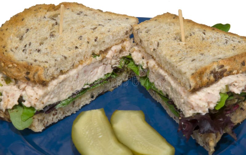 Tuna salad sandwich, on flax toast with pickles on white. Tuna salad sandwich, on flax toast with pickles on white