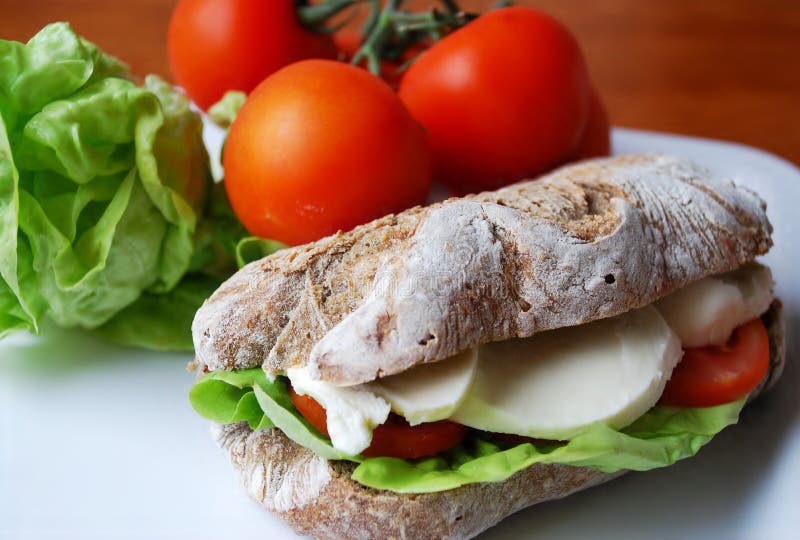 Panino Con Il Prosciutto, La Mozzarella Ed Il Pomodoro Fotografia Stock
