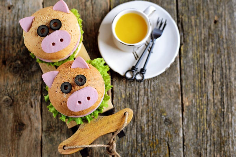 Panino con il prosciutto, il formaggio e la lattuga sotto forma di maiale sveglio - un simbolo di 2019 Fondo di Natale della prim fotografia stock Panino con il prosciutto, il formaggio e la lattuga sotto forma di maiale sveglio - un simbolo di 2019 Fondo di Natale della prim fotografia stock