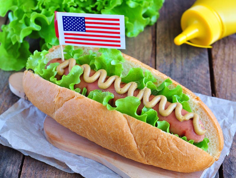 Panino dell'hot dog con la salsa e la lattuga di senape gialle immagine stock Panino dell'hot dog con la salsa e la lattuga di senape gialle immagine stock