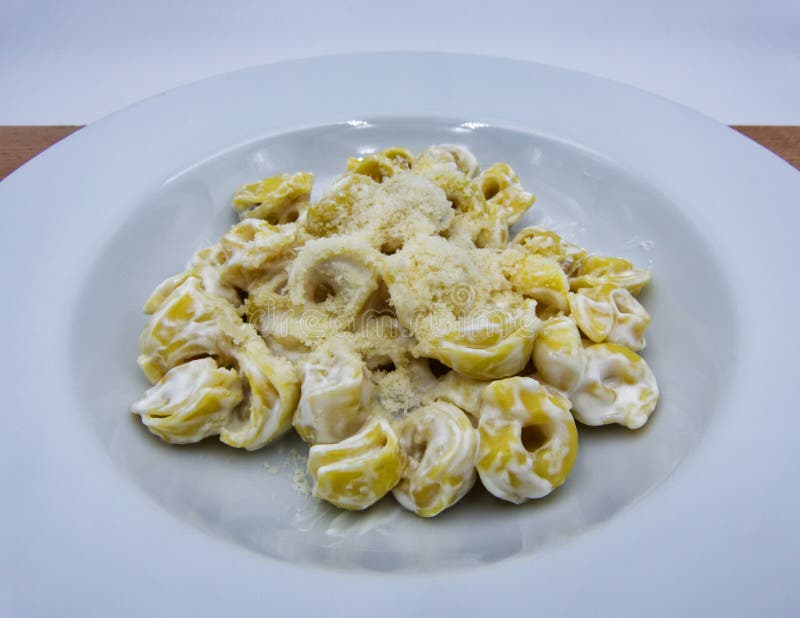 Panna alla Tortellini με την παρμεζάνα σε ένα άσπρο πιάτο, ιταλικά ζυμαρικά στοκ εικόνες με δικαίωμα ελεύθερης χρήσης