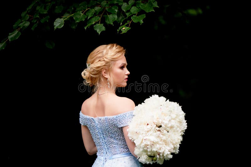 Panna młoda w naturze, z wielkim bukietem peonie W błękitnej, upiększonej sukni, Ślubny spacer, sesja zdjęciowa. fotografia royalty free Panna młoda w naturze, z wielkim bukietem peonie W błękitnej, upiększonej sukni, Ślubny spacer, sesja zdjęciowa. fotografia royalty free