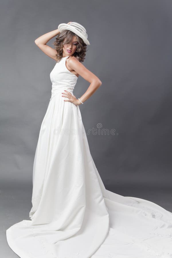 Young bride wearing white wedding dress with hat, looking over her shoulder with copy space. Young bride wearing white wedding dress with hat, looking over her shoulder with copy space