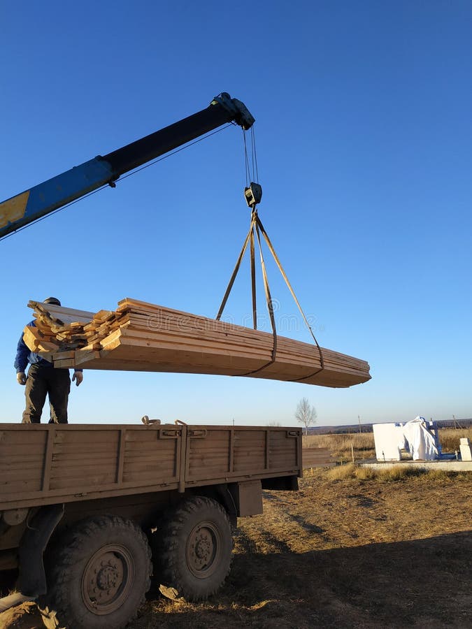 Panneaux de charge fournis au chantier de construction avec une grue, manipulateur photographie stock libre de droits Panneaux de charge fournis au chantier de construction avec une grue, manipulateur photographie stock libre de droits