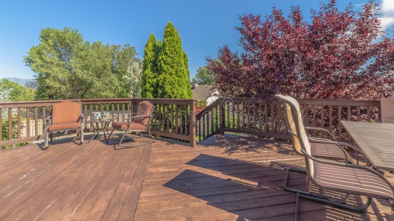 Pano Balcony with furniture and stairs overlooking trees and blue sky on a sunny day