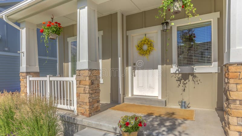 Pano Outdoor stairs porch and white front door with wreath at the facade of a home