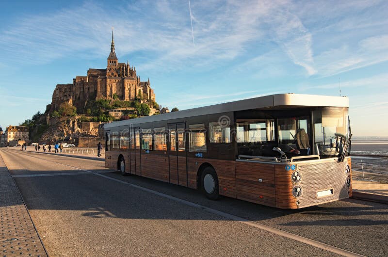 Panorama of ancient Mont Saint Michele abbey in a beautiful spring morning. Special bus brought first tourists to the Abbey. Normandy, France.