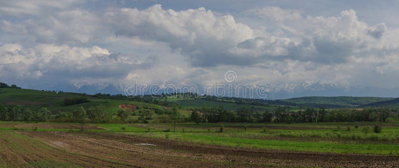 Panorama av fält och Carpathians berg, Transylvanian, romare royaltyfri bild Panorama av fält och Carpathians berg, Transylvanian, romare royaltyfri bild