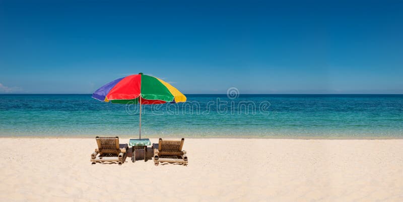 Panorama with bright umbrella and beach chairs with copyspace