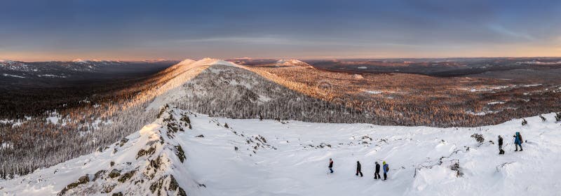 Panorama com grupo de turistas que caminham nas montanhas do inverno fotografia de stock royalty free Panorama com grupo de turistas que caminham nas montanhas do inverno fotografia de stock royalty free