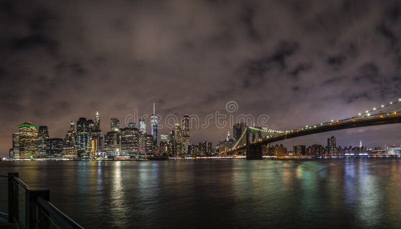Panorama céntrico de New York City Manhattan en la noche con los rascacielos iluminados sobre East River foto de archivo Panorama céntrico de New York City Manhattan en la noche con los rascacielos iluminados sobre East River foto de archivo