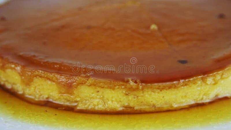 Panorama de gros plan au doux fait maison flan découpé en tranches de cycle servi avec le sirop de caramel banque de vidéos