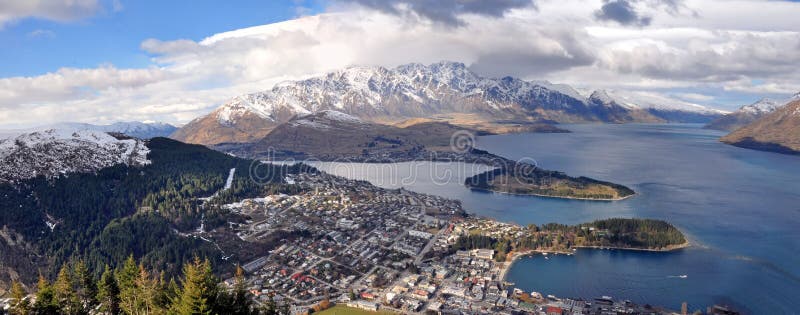 Panoramic view of popular tourist destination Queenstown, Lake Wakatipu and the Remarkables mountain range. Otago, New Zealand. In the foreground is Kelvin Heights, Frankton Arm. Panoramic view of popular tourist destination Queenstown, Lake Wakatipu and the Remarkables mountain range. Otago, New Zealand. In the foreground is Kelvin Heights, Frankton Arm.