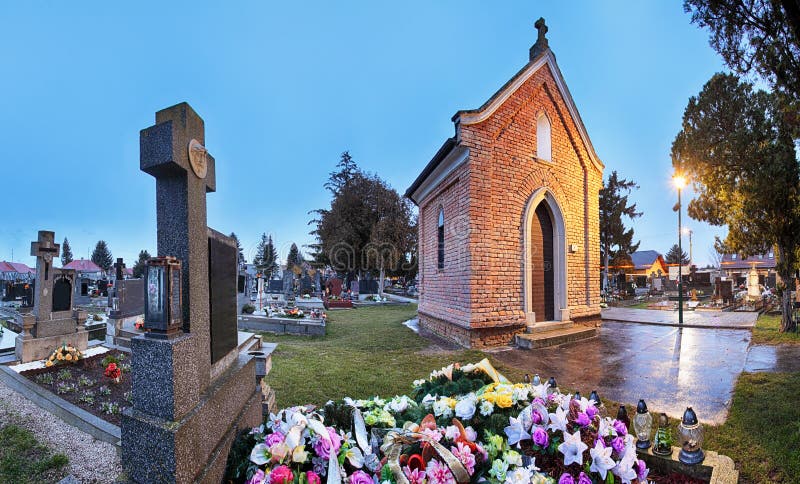 Panorama del cimitero alla notte con la cappella ed i fiori fotografia stock libera da diritti