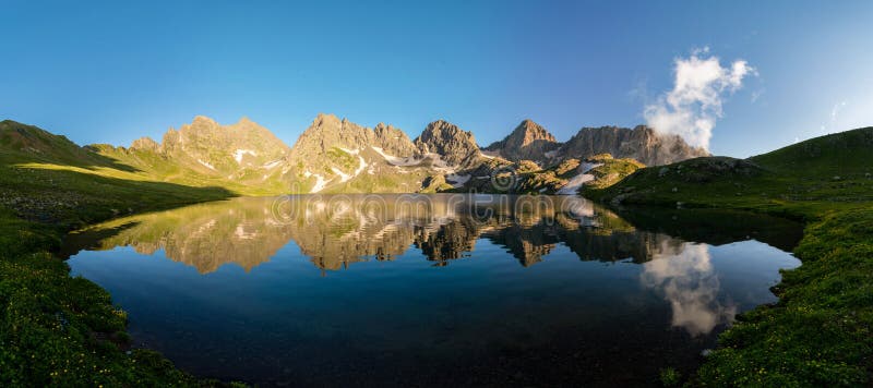 Panorama del lago Tobavarchkhili en la puesta del sol, montañas de Egrisi, Svaneti, Georgia imagen de archivo Panorama del lago Tobavarchkhili en la puesta del sol, montañas de Egrisi, Svaneti, Georgia imagen de archivo
